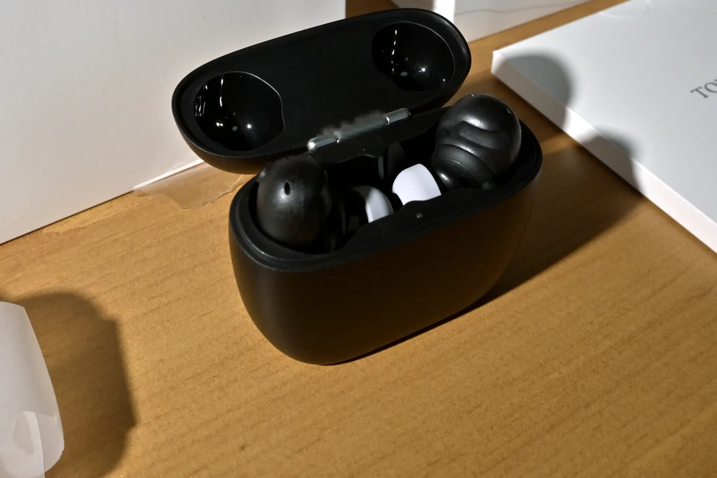 ふたを開けた黒い充電ケースに、丸みのある黒いイヤホンが左右に収まっている